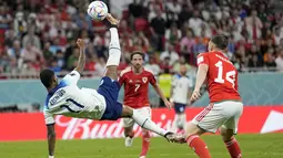 Penyerang Inggris Marcus Rashford menendang bola di depan pemain Wales pada pertandingan terakhir Grup B di Ahmad bin Ali Stadium, Rabu (30/11/2022) dini hari WIB. Timnas Inggris melaju ke Babak 16 Besar Piala Dunia 2022 setelah mengalahkan tetangganya, Wales, 3-0 . (AP Photo/Abbie Parr)