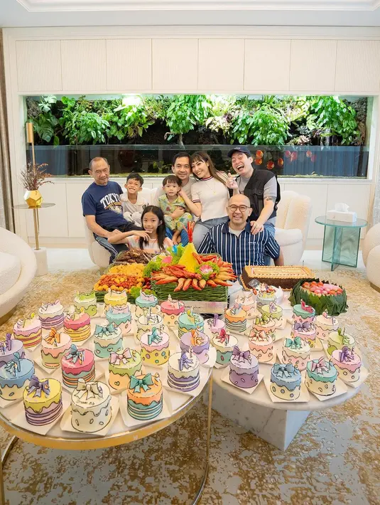 Potret bahagia Ayu Dewi bersama keluarga dan dua sahabatnya, Iwet Ramadhan dan Edric Tjandra. Selain tumpeng, tampak ada 39 kue  yang dipesan sendiri oleh Ayu Dewi. [Instagram/mrsayudewi]
