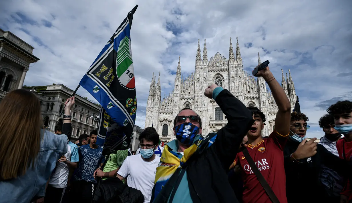 Para pendukung dan fans Inter Milan mengibarkan bendera dan meneriakkan yel-yel di kawasan Piazza Duomo, Milan, Minggu (2/5/2021) merayakan kepastian Inter Milan merebut gelar juara Scudetto Liga Italia 2020/2021. (AFP/Piero Cruciati)