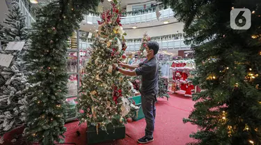 Pekerja merapikan pernak-pernik Natal di Mal Artha Graha, Jakarta, Sabtu (4/12/2021). Jelang perayaan Natal 25 Desember sejumlah mal di ibukota mulai menjual berbagai kebutuhan Natal mulai dari pernak-pernik hingga pohon Natal dengan kisaran harga Rp10.000-Rp5 juta. (Liputan6.com/Faizal Fanani)