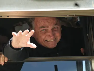 Mantan Presiden Brasil Jair Bolsonaro melambai kepada pendukungnya di markas Partai Liberal di Brasilia, Brasil, Kamis (30/3/2023). (AP Photo/Eraldo Peres)