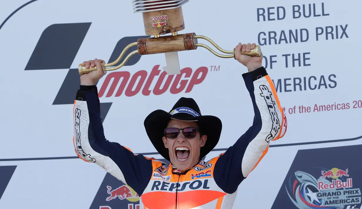 Marc Marquez mengangkat pialanya setelah berhasil finish diurutan pertama pada MotoGP Amerika di Austin, Texas, (23/4). Valentino Rossi meraih Posisi kedua dan posisi ketiga ditempati Dani Pederosa. (AP Photo/Eric Gay)