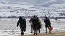 Sejumlah imigran berjalan melewati hamparan salju setelah menyeberang dari perbatasan Macedonia di dekat desa Miratovac, Serbia, (18/1/2016). (REUTERS/Marko Djurica)