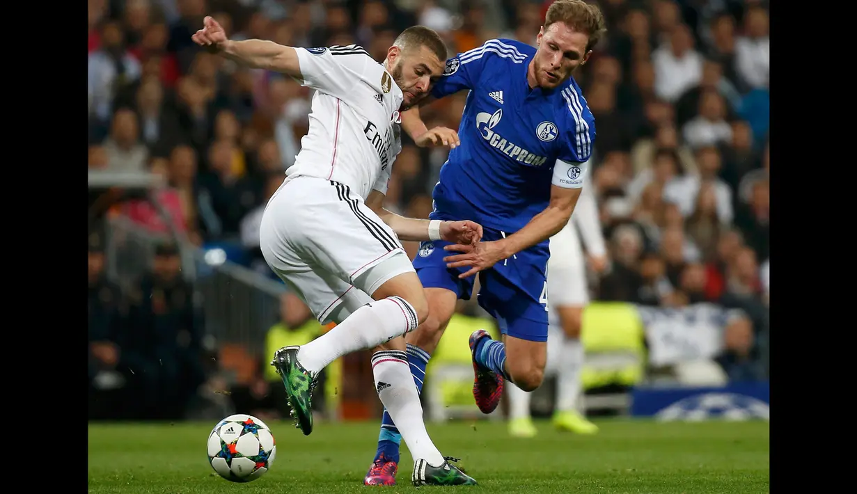 Penyerang Real Madrid, Karim Benzema (kiri) berusaha melewati bek Schalke 04 Benedikt Howedes di leg kedua 16 besar Liga Champions di Stadion Santiago Bernabeu, Madrid, Spanyol, (10/3/2015). Schalke 04 Menang 4-3 atas Real Madrid. (Reuters/Susana Vera)
