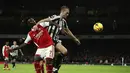 Gelandang Arsenal, Bruno Saka berebut bola denganpemain Newcastle United, Dan Burn selama pertandingan lanjutan Liga Inggris di stadion Emirates di London, Rabu (4/1/2023). Hasil ini membuat Arsenal kini mengumpulkan 44 poin di puncak klasemen dan Newcastle berada di posisi ketiga dengan 35 poin. (AP Photo/Ian Walton)