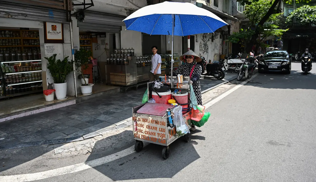 Saat suhu mencapai 38 derajat Celcius pada Kamis (31/5), kawasan kota tua Hanoi yang biasanya ramai dengan sepeda motor, turis, dan penjual mie, terlihat sepi. (Photo by Nhac NGUYEN / AFP)