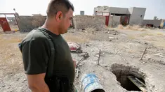 Seorang anggota pasukan Peshmerga bersenjata berjaga di terowongan tempat persembunyian militan ISIS selama operasi penyerangan di Mosul, Irak (19/10). Penemuan terowongan milik militan ISIS itu terdapat di dalam bangunan. (REUTERS/Thaier Al-Sudani)