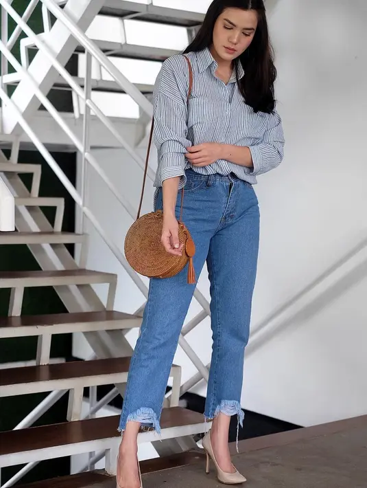Kemeja garis-garis  kecil berwarna biru ini dikenakan Alice dengan paduan celana jeans retronya. Tampilannya ini terlihat sedikit formal, terlebih Alice menggunakan heels berwarna khaki.  (Instagram/alicenorin)