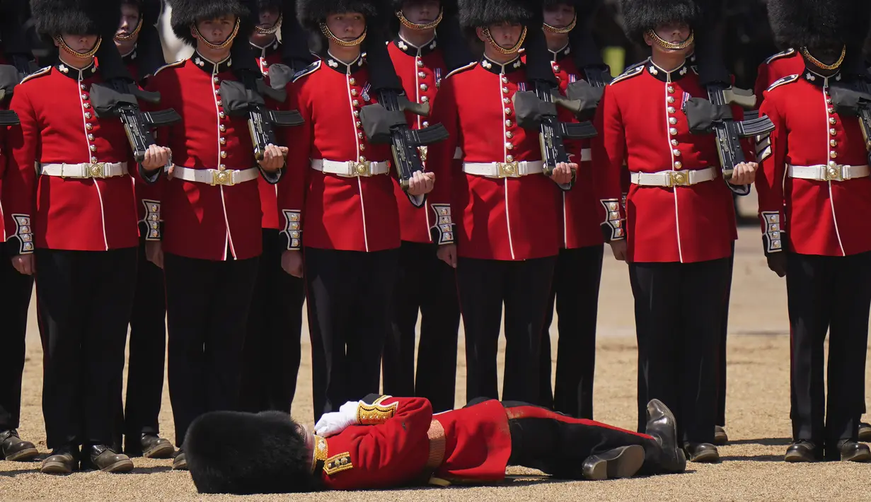 <p>Seorang petugas Pengawal Welsh pingsan dalam cuaca panas selama parade militer yang dikenal sebagai Colonel's Review, latihan terakhir persiapan parade Trooping the Color tahunan, di Horse Guards Parade di London, Sabtu, 10 Juni 2023. (AP Photo/Alberto Pezzali)</p>