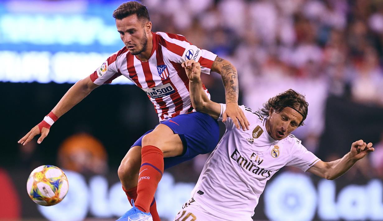 Gelandang Real Madrid, Luka Modric berebut bola dengan gelandang Atletico Madrid, Saul Niguez selama laga International Champions Cup 2019 di Arena Stadium Metlife, New Jersey (27/7/2019). Atletico menang telak 7-3 atas Real Madrid. (AFP Photo/Johannes Eisele)