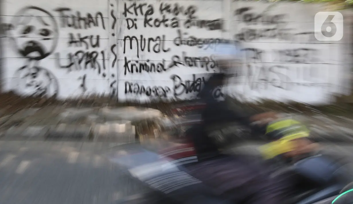 Kendaraan melintas di depan mural di Jalan Raya Citayam, Depok, Jawa Barat, Rabu (25/8/2021). Mural tersebut merupakan wujud ekspresi dari sejumlah seniman serta sebagai media penyampaian kritik sosial kepada pemerintah di tengah pandemi COVID-19. (Liputan6.com/Herman Zakharia)