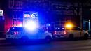 Kendaraan polisi berjaga di luar toko tato Sol Tribe di Broadway di mana dua wanita tewas ditembak dan seorang pria terluka di Denver, Colorado (27/12/2021). Polisi Denver sedang menyelidiki dua penembakan terpisah pada Senin malam. (Michael Ciaglo/Getty Images/AFP)