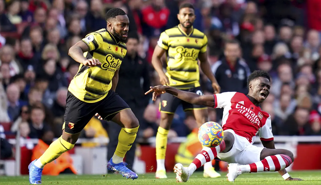 rsenal, Bukayo Saka berebut bola dengan pemain Watford, Danny Rose pada pertandingan lanjutan Liga Inggris di Stadion Emirates, London, Minggu (17/11/2021). Kemenangan ini membuat Arsenal naik ke posisi kelima dengan 20 poin. (John Walton/PA via AP)