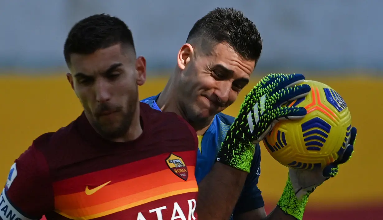 Kiper Udinese, Juan Musso (kanan) menangkap bola dari ancaman gelandang AS Roma, Lorenzo Pellegrini dalam laga lanjutan Liga Italia 2020/21 pekan ke-22 di Olimpico Stadium, Roma, Minggu (14/1/2021). Udinese kalah 0-3 dari AS Roma. (AFP/Alberto Pizzoli)