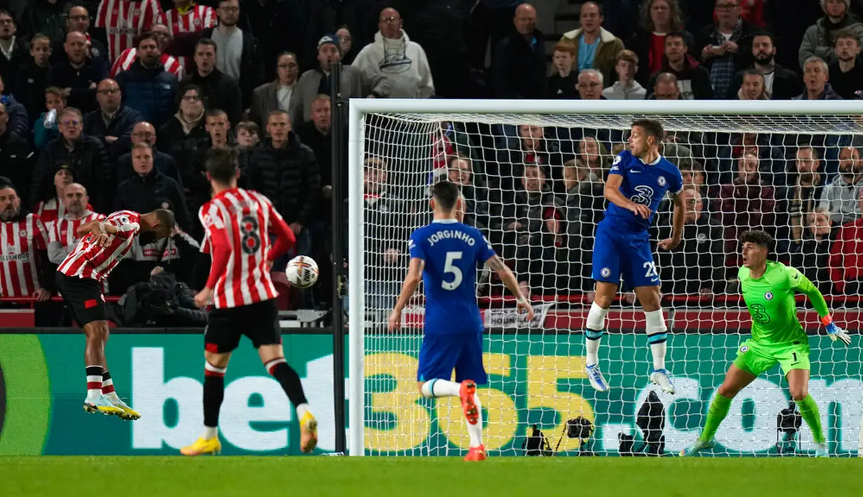 Pemain Brentford Ivan Toney (kiri) mencoba untuk menyundul bola ke gawang Chelsea yang dijaga kiper Kepa Arrizabalaga (kanan) pada pertandingan sepak bola Liga Inggris di Stadion Gtech Community, London, Inggris, 19 Oktober 2022. Pertandingan berakhir imbang 0-0. (AP Photo/Alastair Grant)