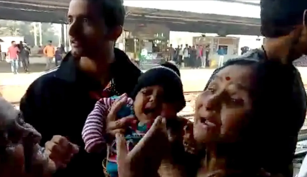 Gambar dari video pada 20 November 2018, bayi India berada dalam gendongan setelah terjatuh tepat di samping rel di stasiun kereta api di Mathura, Uttar Pradesh. Bayi itu terlepas dari gendongan dan jatuh saat ibunya turun dari kereta api (NNIS / AFP)
