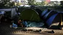 Seorang imigran Afghanistan beristirahat saat bertahan di sebuah kamp darurat di jalan raya A1 di utara pinggiran Kota Paris Saint-Denis (16/9/2020). (AFP/Christophe Archambault)