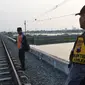 Petugas gabungan dari Polsuska dan Babinkamtibmas Kemijen Semarang memeriksa rel kereta api di Jalur Kemijen, Minggu (3/6). Pemeriksaan rel dilakukan untuk pengamanan jalur kereta api jelang arus mudik lebaran 2018. (Liputan6.com/Gholib)