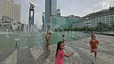 Sejumlah anak bermain air di kolam Bundaran HI, Jakarta, Senin (17/6/2019). Meski ada larangan berenang, sejumlah anak tetap nekat menyebur ke kolam Bundaran HI. (Liputan6.com/Herman Zakharia)