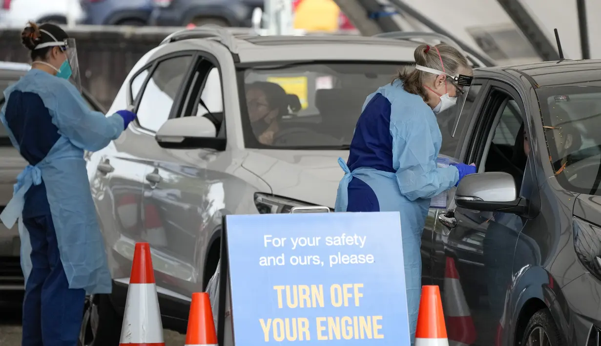 Staf mengumpulkan sampel di klinik pengujian COVID-19 drive-thru di Pantai Bondi di Sydney, Sabtu (8/1/2022). Negara bagian terpadat di Australia itu memberlakukan kembali beberapa pembatasan dan menangguhkan operasi elektif ketika kasus COVID-19 melonjak ke rekor baru lainnya. (AP Photo/Mark Baker)