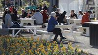 Pelanggan menikmati makan siang di bawah sinar matahari di Pasar Riverside di Christchurch, Selandia Baru pada Minggu (9/8/2020). Selandia Baru pada Minggu kemarin telah berhasil melewati 100 hari tanpa merekam kasus Virus Corona COVID-19 yang ditularkan secara lokal. (AP Photo/Mark Baker)