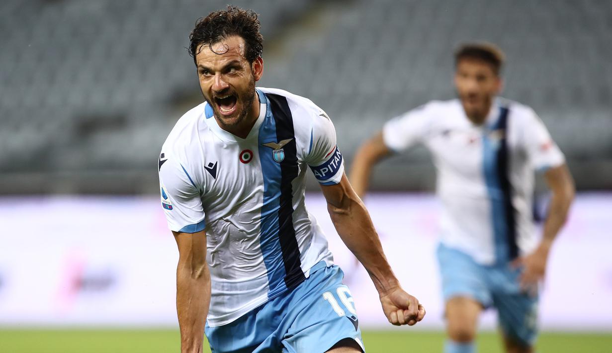 Gelandang Lazio, Marco Parolo, merayakan gol yang dicetaknya ke gawang Torino pada laga lanjutan Serie A pekan ke-29 di Stadion Olimpico Grande Torino, Rabu (1/7/2020) dini hari WIB. Lazio menang 2-1 atas Torino. (AFP/Isabella Bonotto)