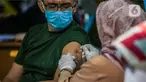 Seorang pria mendapatkan vaksinasi dosis ketiga (booster) di Taman Suropati, Jakarta, Selasa (5/7/2022). Aturan vaksin booster sebagai syarat baru perjalanan bagi masyarakat diperkirakan akan mulai berlaku 2 pekan dari sekarang. (Liputan6.com/Faizal Fanani)