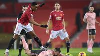 Striker Manchester United Anthony Martial melanggar pemain Sheffield United Phil Jagielka dalam lanjutan Liga Inggris di Old Trafford, Kamis (28/1/2021). (AP Photo/Laurence Griffiths,Pool)