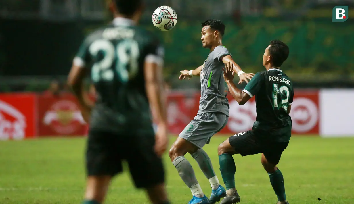 Pemain Persebaya Surabaya, Koko Ari Araya (tengah) berebut bola dengan pemain Persikabo 1973, Roni Sugeng dalam laga pekan pertama BRI Liga 1 2022/2023 antara Persikabo 1973 melawan Persebaya Surabaya di Stadion Pakansari, Bogor, Senin (25/7/2022) malam WIB. (Bola.com/M Iqbal Ichsan)