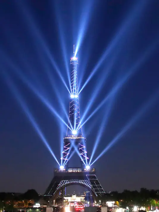 Pertunjukan cahaya menerangi Menara Eiffel saat perayaan ulang tahunnya ke-130 tahun di Paris, Rabu (15/5/2019). Paris memberikan ucapan ulang tahun kepada Menara Eiffel dengan pertunjukan laser yang rumit menelusuri kembali sejarah 130 tahun monumen itu. (AP/Christophe Ena)