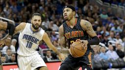 Pemain Atlanta Hawks, Kent Bazemore (kanan) mencoba melewati hadangan pemain Orlando Magic, Evan Fournier (kiri)  pada laga NBA basketball game di Amway Center, (4/1/2017). Atlanta menang 111-92. (AP/John Raoux)