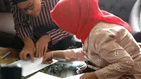 Berbusana adat Jawa, Gubernur Jawa Tengah Ganjar Pranowo mengambil rapor anaknya di SMAN 3 Semarang, Kamis (19/12). (Liputan6.com/ Istimewa)