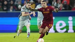 Penyerang RB Salzburg Noah Okafor berusaha untuk mencetak gol melewati bek AS Roma Gianluca Mancini pada leg pertama playoff babak 16 besar Liga Europa di Red Bull Arena, Salzburg, Jumat (17/2/2023) dini hari WIB. Di atas kertas skuad Jose Mourinho masih lebih baik daripada tim tamu, tapi faktanya di lapangan tidak demikian. (AP Photo/Petr David Josek)