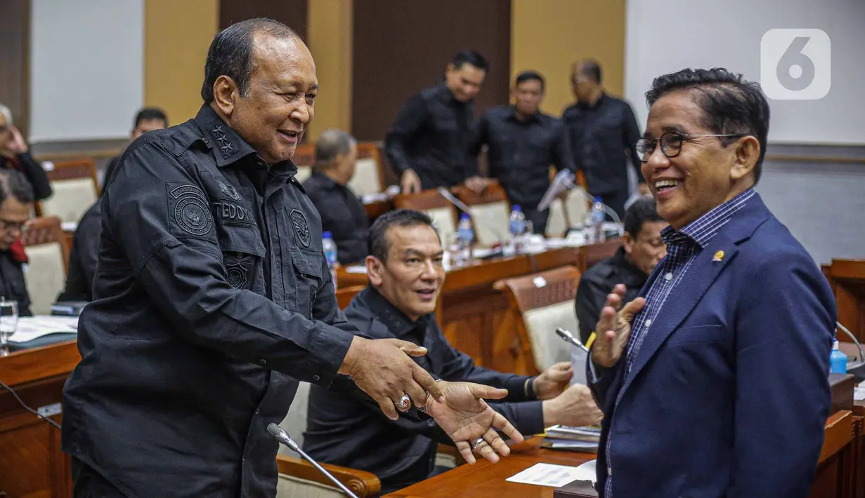 Wakil Kepala Badan Intelijen Negara (Waka BIN) Letnan Jenderal TNI (Purn) Teddy Lhaksmana Widya Kusuma (kiri) berjabat tangan dengan anggota Komisi I DPR Bakri HM (kanan) sebelum rapat kerja di kompleks Parlemen, Jakarta, Kamis (8/6/2023). (Liputan6.com/Faizal Fanani)