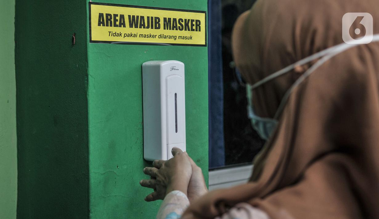 Guru menggunakan hand sanitizer sebelum memasuki kelas saat Simulasi Persiapan Kelas Hybrid dalam Pembelajaran Jarak Jauh di SMPN 255, Jakarta, Selasa (30/3/2021). Kelas Hybrid merupakan model sekolah tatap muka secara rotasi dengan jumlah kehadiran siswa 50 persen. (merdeka.com/Iqbal S Nugroho)