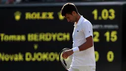 Petenis Serbia, Novak Djokovic berjalan di lapangan pada babak perempatfinal Wimbledon 2017 saat bertemu petenis Ceko, Tomas Berdych, Rabu (12/7). Djokovic harus menyerah dari Berdych saat pertandingan memasuki set kedua. (Gareth Fuller/PA via AP)