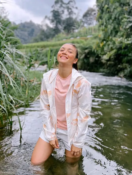 Saat bertemu sungai, Angela Gilsha, merasa tak afdol bila tak terjun ke dalamnya. Ia rela basah-basahan. (Foto: Instagram/@angelagilsha)