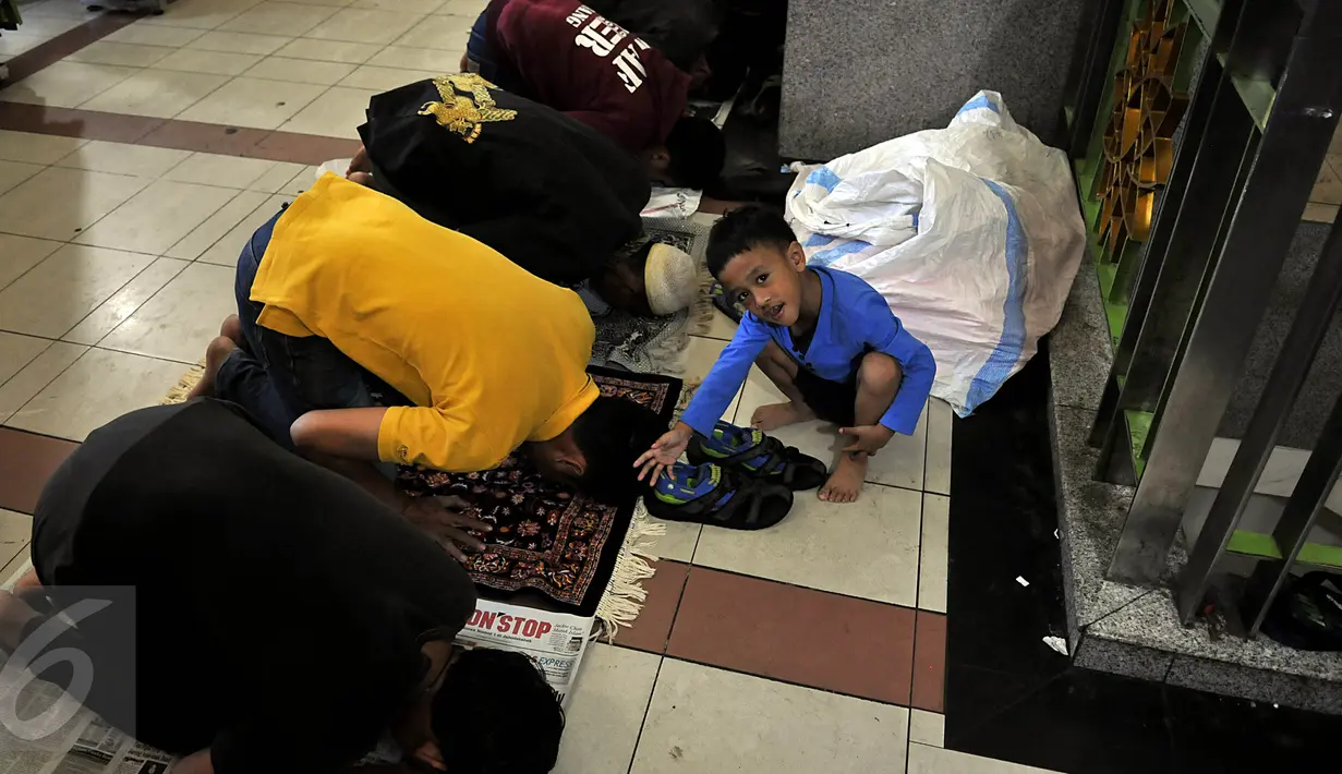 Seorang anak terlihat menunggu di saat sejumlah umat muslim melaksanakan salat Jumat pertama pada bulan Ramadan 1436 H, di lorong Blok A-B di Tanah Abang, Jakarta, Jumat (19/6/2015). (Liputan6.com/Johan Tallo)