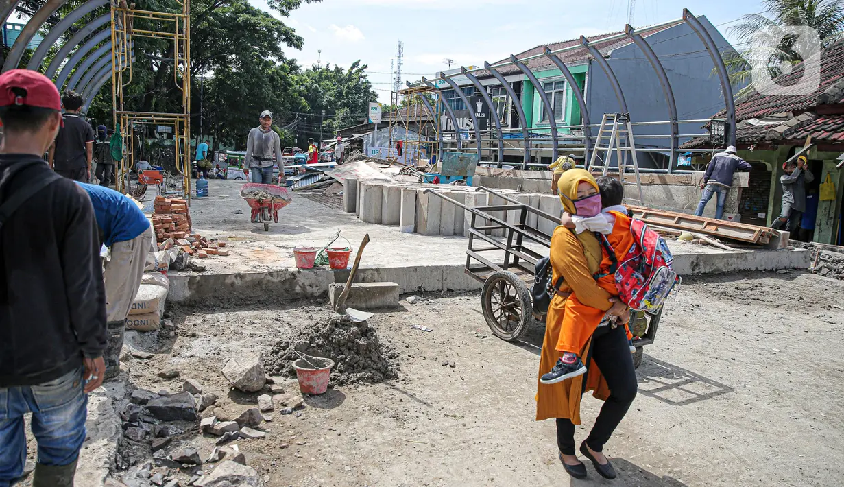 Warga melintas di dekat pembangunan revitalisasi Jembatan Cibubur, Jakarta, Senin (24/10/2022). Jembatan Cibubur yang saat ini sedang direvitalisasi, akan dilengkapi akses untuk pejalan kaki. Jembatan Cibubur yang menghubungkan Pasar Rebo dan Ciracas itu akan ditinggikan guna menghindari genangan ketika permukaan Kali Cipinang meninggi dan ditargetkan selesai pada bulan November 2022. (Liputan6.com/Faizal Fanani)