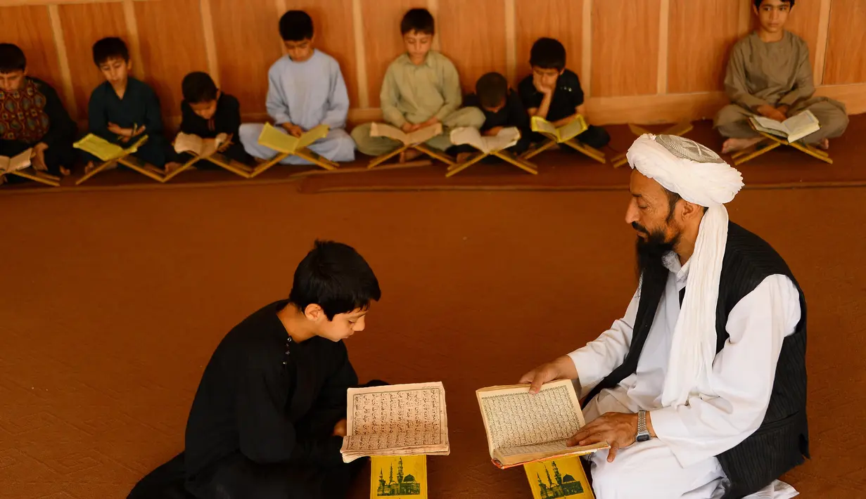 Anak-anak mempelajari Alquran selama bulan suci Ramadan di masjid di Herat, Afghanistan, Sabtu (19/5). Anak-anak Afghanistan lebih memperdalam Alquran di saat Ramadan. (HOSHANG HASHIMI/AFP)