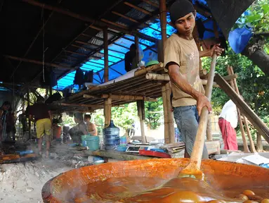 Pekerja mengaduk adonan untuk membuat dodol Betawi di kawasan Studio Alam TVRI, Cilodong, Depok (31/5). Dodol ini menjadi salah satu kuliner khas Betawi yang sering dijumpai ketika Lebaran. (Merdeka.com/Arie Basuki)