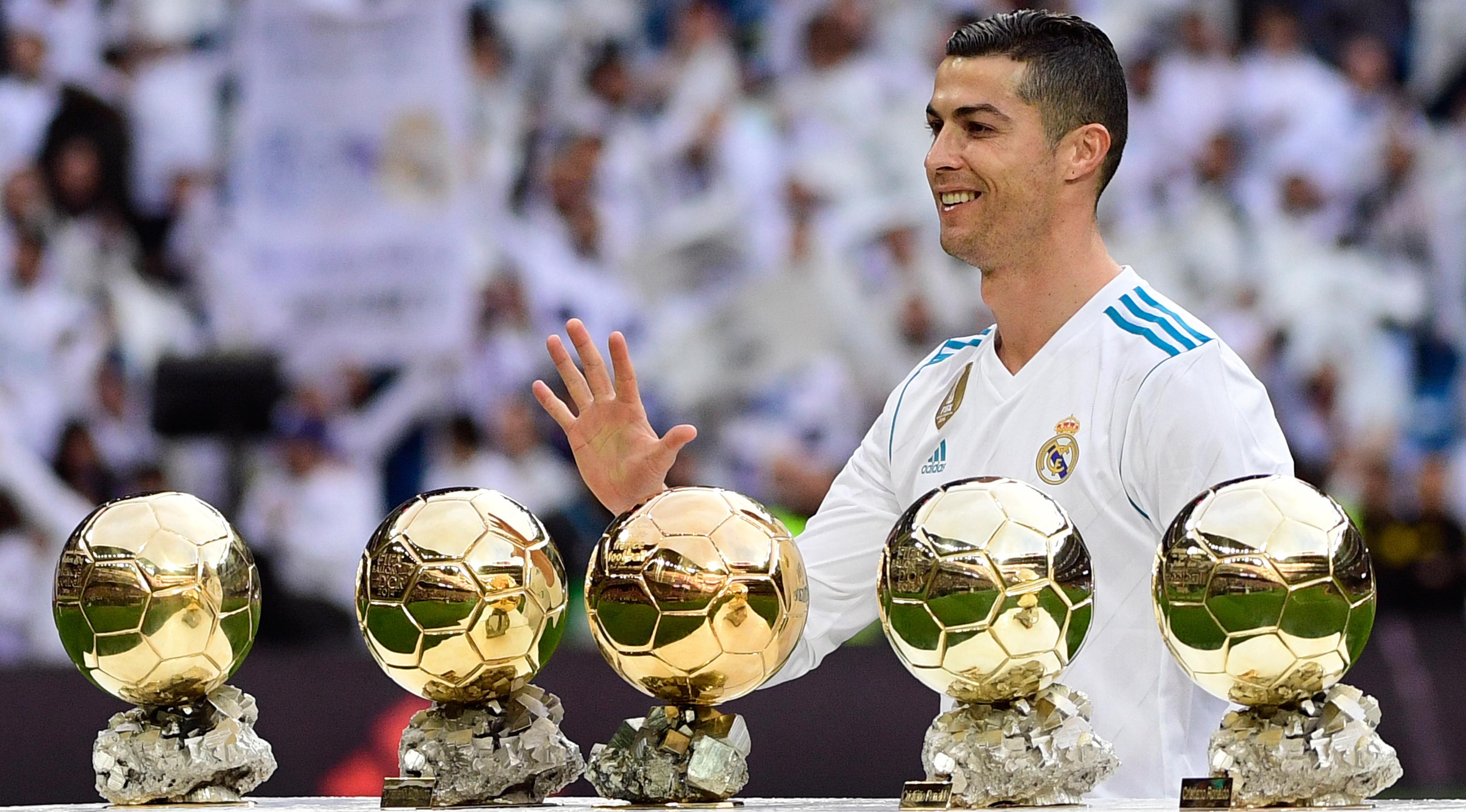 Bintang Real Madrid, Cristiano Ronaldo berpose dengan kelima trofi Ballon d'Or sebelum laga Real Madrid vs Sevilla di Stadion Santiago Bernabeu, Sabtu (9/12). Ronaldo hanya berpose dengan kelima trofi Ballon d'Or seorang diri. (PIERRE-PHILIPPE MARCOU/AFP)