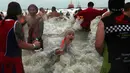 Warga Belgia menceburkan diri ke perairan Laut Utara untuk merayakan akhir pekan perrtama 2019 di Ostend, Sabtu (5/1). Tak sekadar bermain air, sebagian warga juga beraksi dengan kostum berwarna-warni. (AP/Francisco Seco)