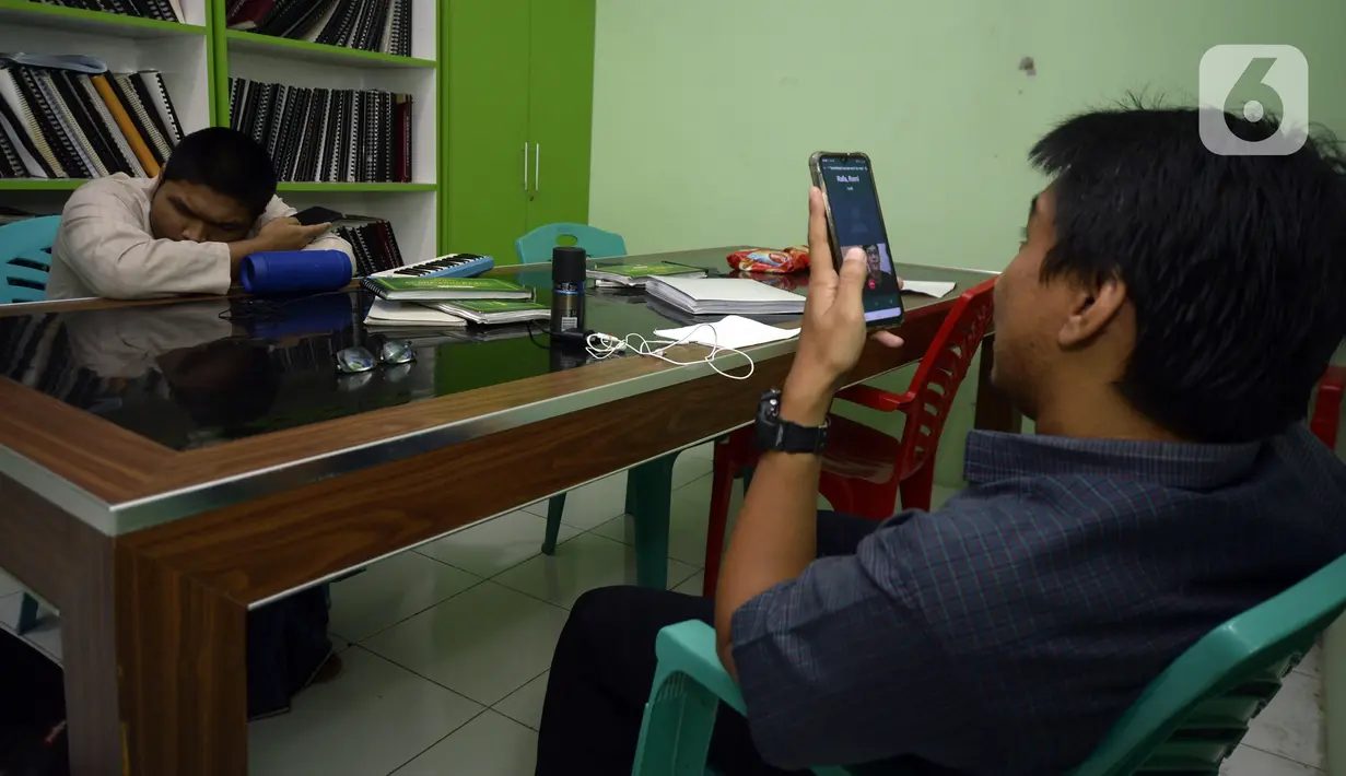 Guru Wahyu Adi Prasetyo mengajar secara online di sekolah tunanetra Yayasan Raudlatul Makfufin, Buaran, Serpong, Tangerang Selatan, Banten, Senin (10/8/2020). Keterbatasan kuota internet membuat para guru membatasi waktu belajar yang berlangsung sejak pandemi COVID-19. (merdeka.com/Dwi Narwoko)
