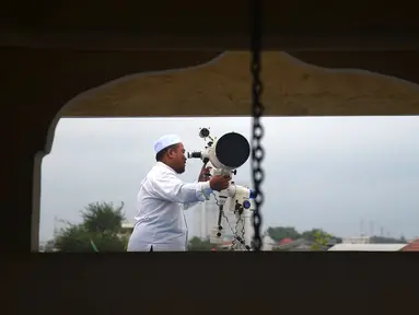Petugas meneropong posisi hilal (bulan) dari Pondok Pesanteren Al-Hidayah Jakarta, Selasa (15/5). Pemantauan hilal ini dilakukan untuk menentukan jatuhnya 1 Ramadan 1439 H. (Merdeka.com/Imam Buhori)