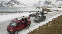Para peselancar mempersiapkan peralatan saat tiba di kawasan pantai  Flackstad, dekat Ramberg, kepulauan Lofoten, Arctic Circle, (10/3/2016). suhu laut berkisar 5-65-6 ∞C sedangkan suhu udara   0∞C.  (AFP/Olivier Morin)