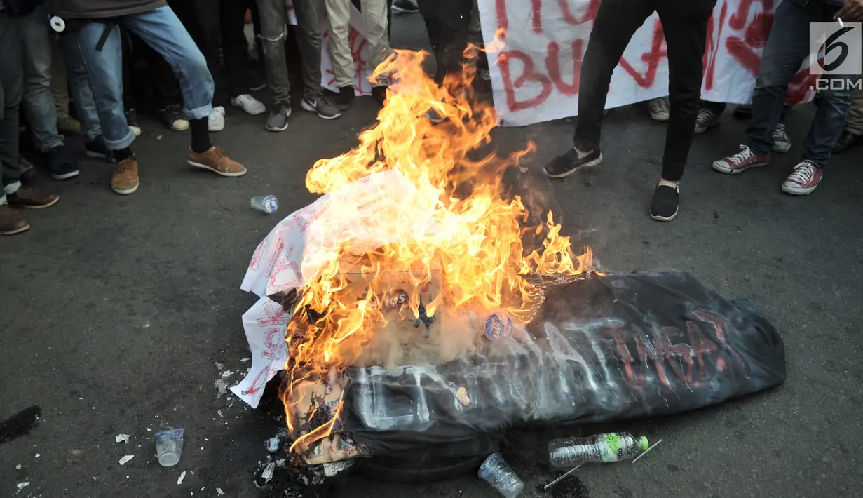 Mahasiswa gabungan se-Jabodetabek membakar ban bekas saat menggelar aksi unjuk rasa di depan Istana Merdeka, Jakarta, Selasa (16/7/2019). Dalam aksi ini sempat terjadi aksi saling dorong dengan pihak kepolisian. (merdeka.com/Iqbal S. Nugroho)