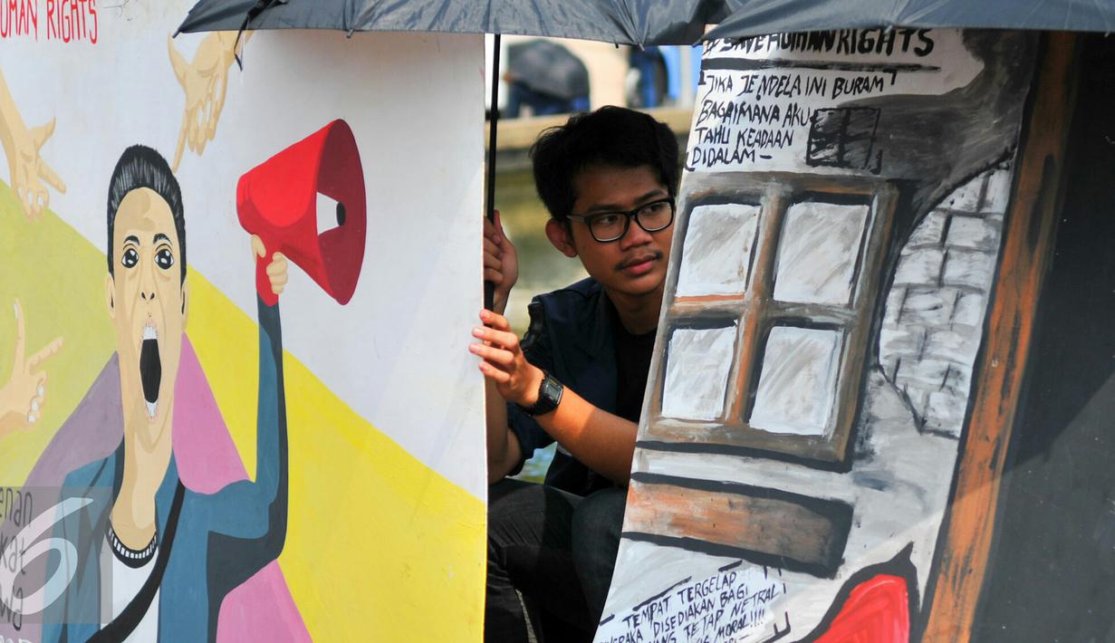 Mahasiswa Trisakti saat menggelar aksi dengan memajang gambar mural bertema kemanusiaan di Bundaran Patung Kuda, Jakarta, Kamis (12/5). Aksi ini bertujuan untuk memperingati tragedi trisakti 12 Mei 98. (Liputan6.com/Yoppy Renato)