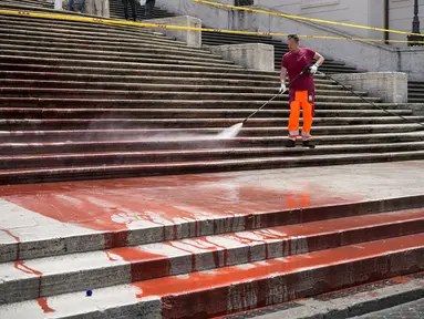 Para pekerja kota Roma membersihkan Spanish Steps setelah para aktivis menyiramkan cat merah di atasnya untuk memprotes kekerasan terhadap perempuan di Roma, Italia, Rabu (26/6/2024). (AP Photo/Andrew Medichini)