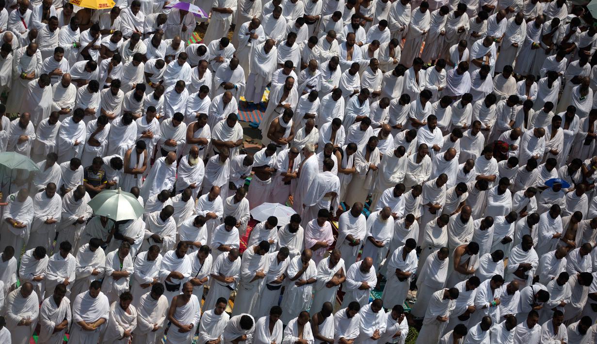 Ribuan jemaah haji melakukan salat zuhur di luar masjid Namirah di Kota Arafah, Arab Saudi (31/8). Masjid ini hanya dibuka setahun sekali, yaitu pada tanggal 9 Dzulhijah, saat jemaah haji melaksanakan wukuf di arafah. (AP Photo / Khalil Hamra)